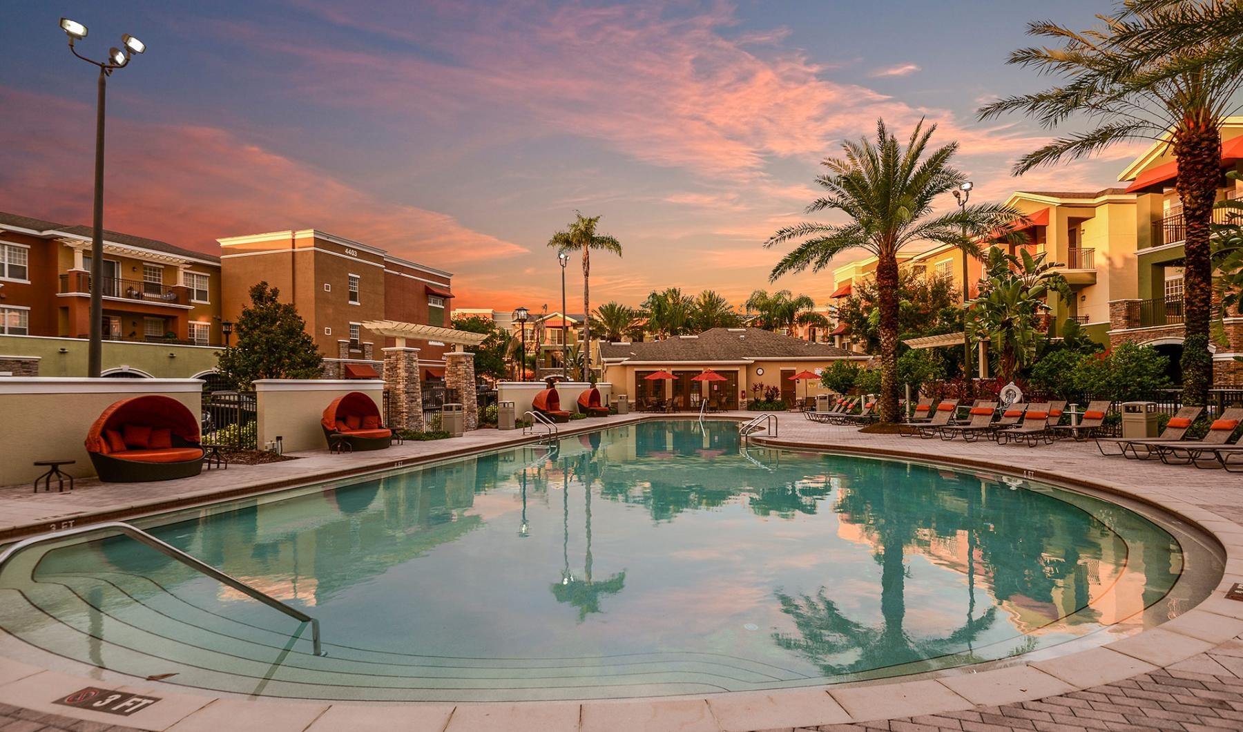 a pool with a sunset in the background